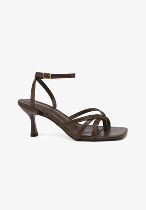 Braune Ledersandalette mit Riemchen, Knöchelriemen und quadratischer, offener Zehenpartie auf weißem Hintergrund.