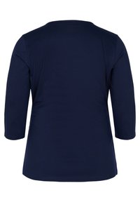 Chemise à manches longues bleu marine montrée de dos avec un col rond et un ourlet droit. Aucun motif ou logo visible.