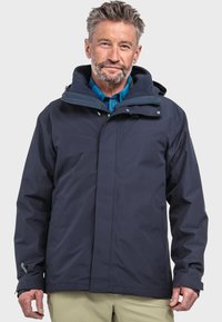 Marineblaue wasserdichte Jacke mit Kapuze, Frontreißverschluss und Druckknöpfen. Sie hat eine glatte Textur und verstellbare Bündchen, ideal für den Einsatz im Freien.