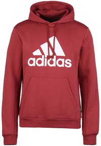 Sweat à capuche bordeaux en tissu doux avec une poche avant, une capuche à cordon de serrage et un grand logo Adidas blanc sur la poitrine.