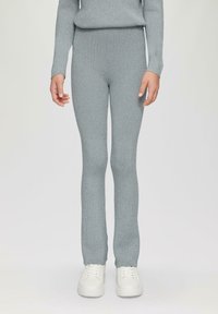 Lichtblauwe geribde leggings gemaakt van een textuurstof, met een aansluitend ontwerp en gecombineerd met witte sneakers.