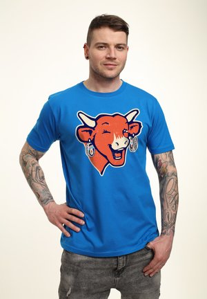 Blå t-shirt med et stort orange ko-graphic med horn, øreringe og et smilende ansigt. Blødt stof, korte ærmer, afslappet pasform.