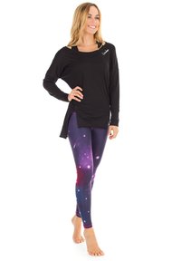 Svart långärmad topp med en sidofick; lila galaxmönstrade leggings med stjärnor och en strukturerad design; använd barfota.