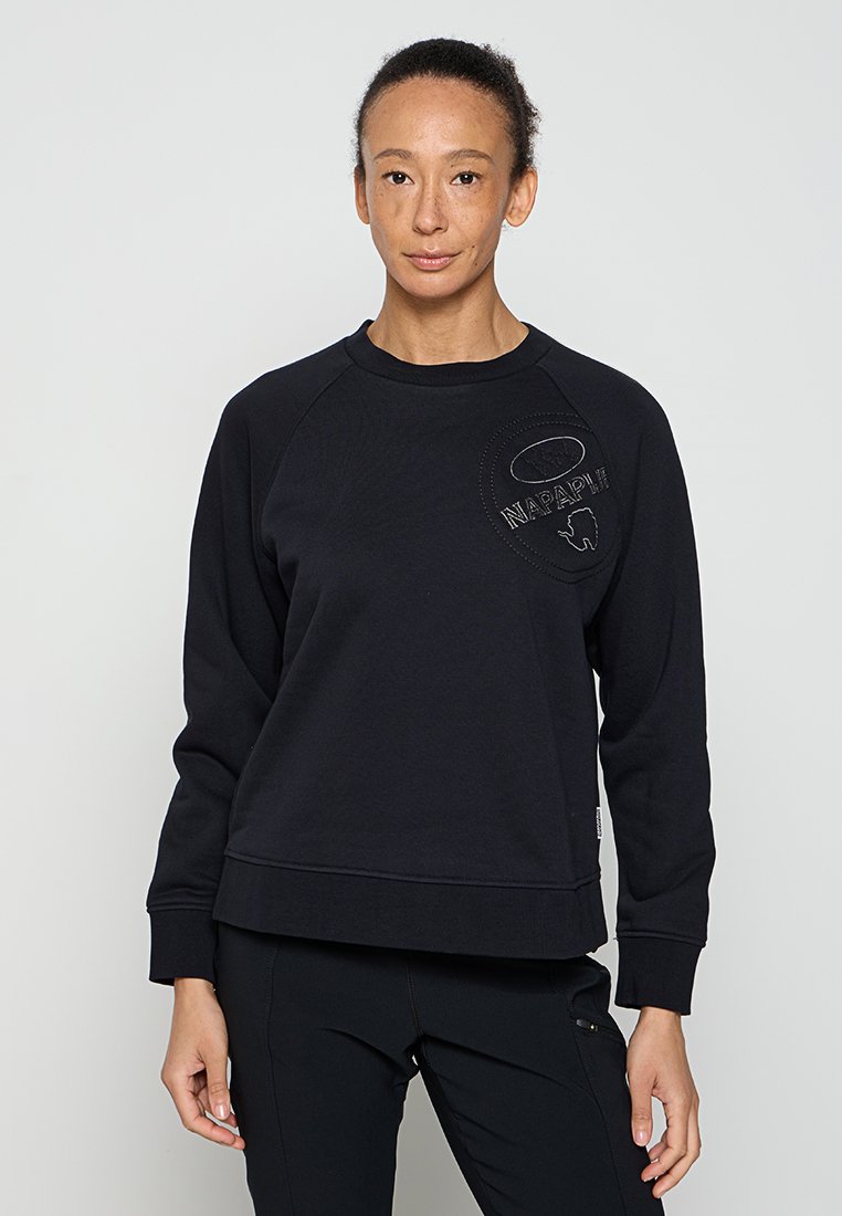 Schwarzer Pullover aus weichem Stoff, mit Raglanärmeln und einem strukturierten, gestickten Logo auf der Brust. Einfaches, lässiges Design.