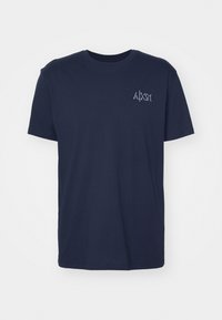 Camiseta de algodón azul marino de manga corta, con cuello redondo y un pequeño logotipo bordado en el lado izquierdo del pecho. Corte clásico y textura suave.