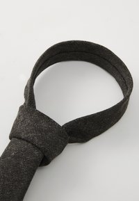 Gray fabric tie with a smooth texture and a slight shimmer. Features a classic knot and a tapered end, suitable for formal wear.