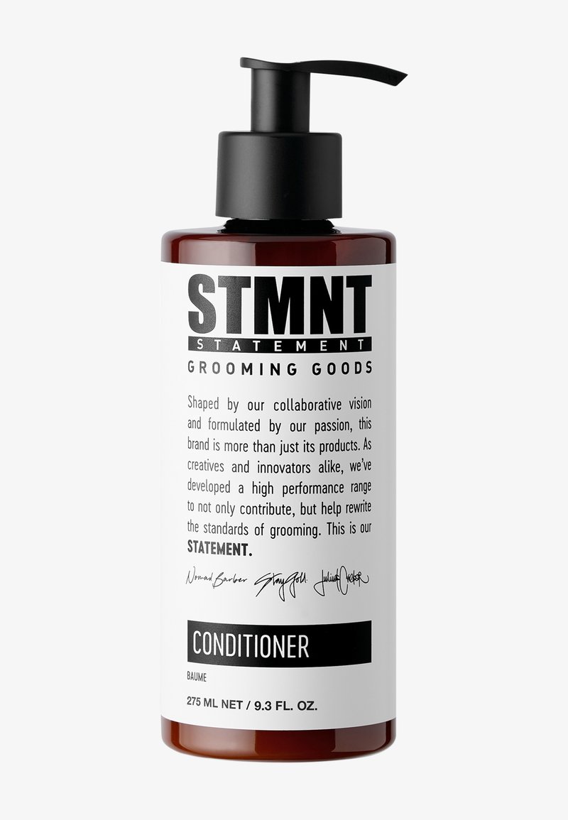 Dunkelbernsteinfarbige Kunststoffflasche mit einem schwarzen Pumpkopf. Weiße Etikettierung mit fettem schwarzem Text. Produkt: STMTNT Conditioner, 275 ml.
