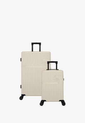 Lichtbeige harde koffer set, met verticale ribbels, zwarte telescopische handvatten en soepele wielen. Inclusief een grotere en een kleinere maat.