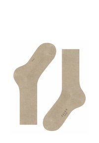 Beżowe bawełniane skarpetki o gładkiej teksturze, z prążkowanym mankietem oraz subtelnym logo na dole. Standardowa długość do kostki.