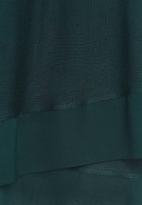 Mörkgrön tyg med ett strukturerat överlager och ett mjukt underlager, med en subtil lyster och mjuk fall.