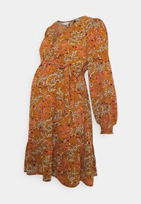 Vestido de maternidade em amarelo mostarda com estampa floral, apresentando mangas longas bufantes, um design em envoltório e uma bainha em camadas. Textura suave.