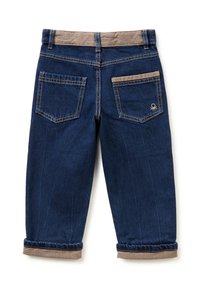 Pantalones de mezclilla azul oscuro con cinturilla y puños en beige. Presenta dos bolsillos traseros y detalles de costura. Dobladillos enrollados en los tobillos.