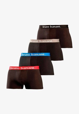 Miesvartalo, joka käyttää mustia bokserialushousuja, joissa on punainen vyötäröosa ja valkoinen "bruno banani" -brändäys, seisoo yksivärisen vaalean taustan edessä.