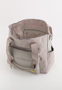 Gray canvas tote bag with two sturdy handles, a zippered main compartment, and a front pocket. Features a mix of smooth and textured surfaces.