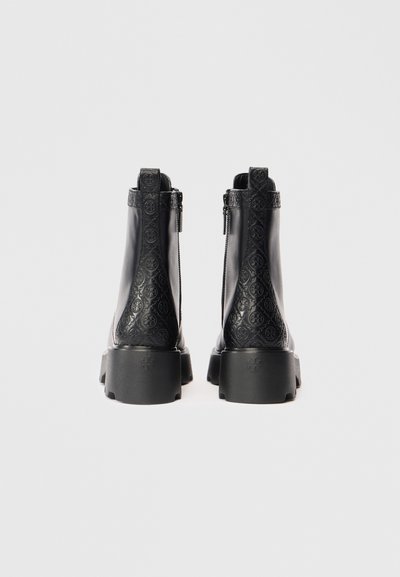 Botas de tobillo de cuero negro con un patrón texturizado, cremalleras laterales y suelas de goma gruesas. Presentan un detalle en relieve en la parte posterior.