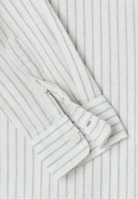 Manica di camicia bianca con strisce verticali grigio chiaro. Presenta un polsino con bottoni, una texture morbida e cuciture pulite.