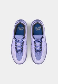 Lila Nike-Sneaker verfügen über ein Obermaterial aus Netz und Textur, runde Schnürsenkel und ein perforiertes Design. Blaue Einlegesohlen sind sichtbar im Inneren.