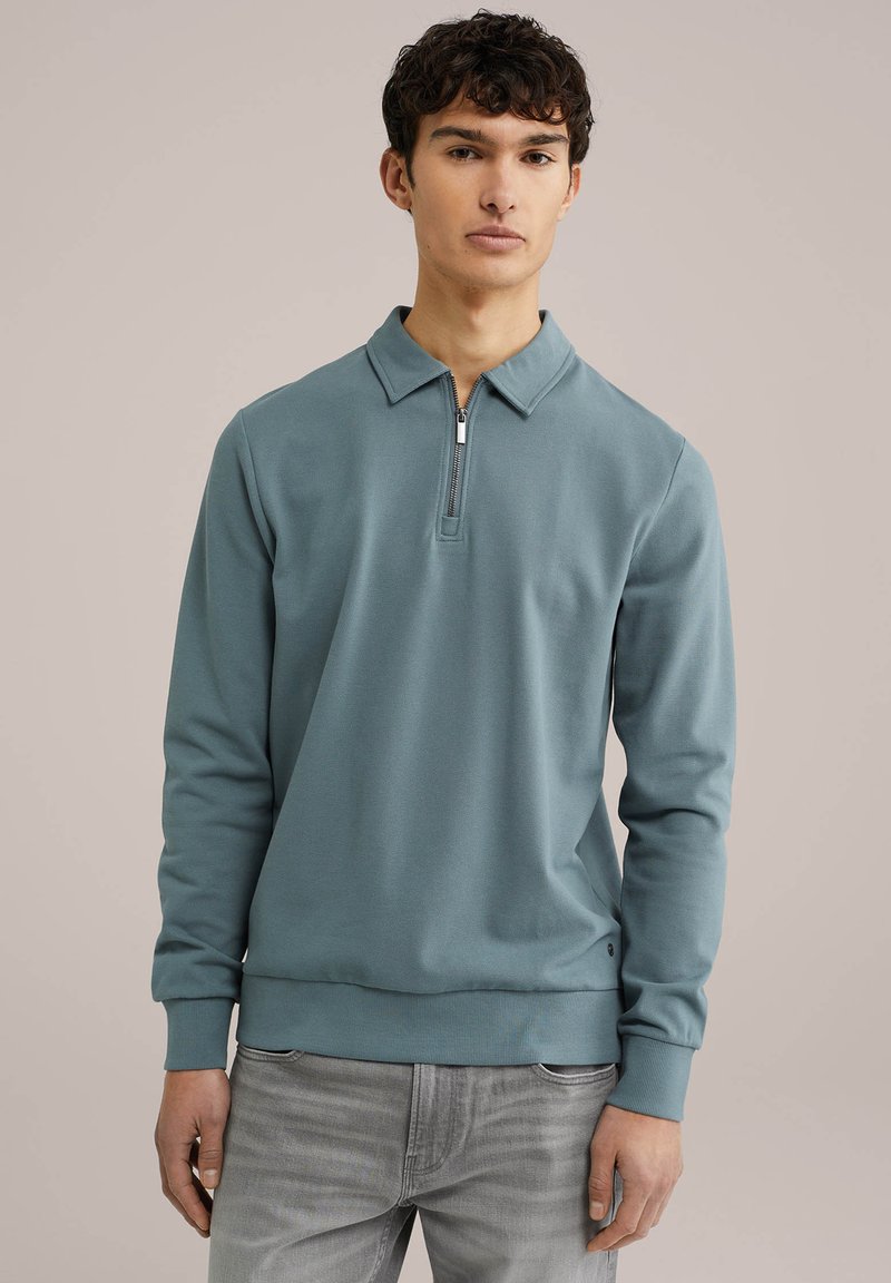 Moška dolgoročna polo majica v teal barvi, narejena iz gladkega blaga. Ima ovratnik s četrtim zadrge ter rebraste manšete in rob.