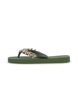 Sandalia plana tipo chancla verde con suela texturizada y tiras decoradas con adornos de piedras de strass doradas y transparentes.