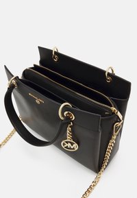 Sac à main en cuir noir avec une finition texturée, quincaillerie dorée, double anses supérieures et une bandoulière en chaîne amovible. Présente des compartiments zippés.
