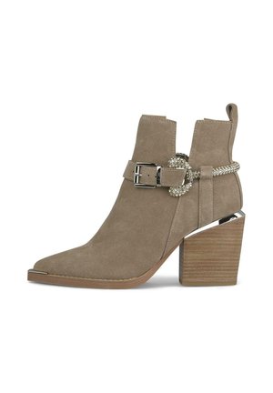 Stivale alla caviglia in suede beige con punta affusolata, dettaglio in fibbia argentata e tacco a cuore in legno decorato con un accento metallico.