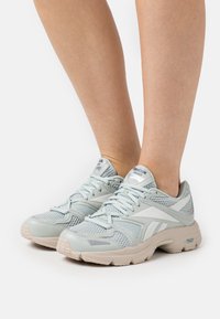 Light blue athletic shoes with a mesh upper, rubber sole, and white accents. Features padded collar and lace-up design.