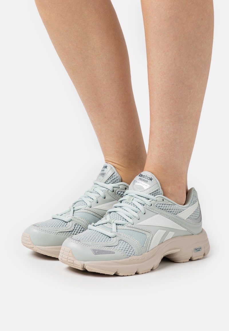 Light blue athletic shoes with a mesh upper, rubber sole, and white accents. Features padded collar and lace-up design.
