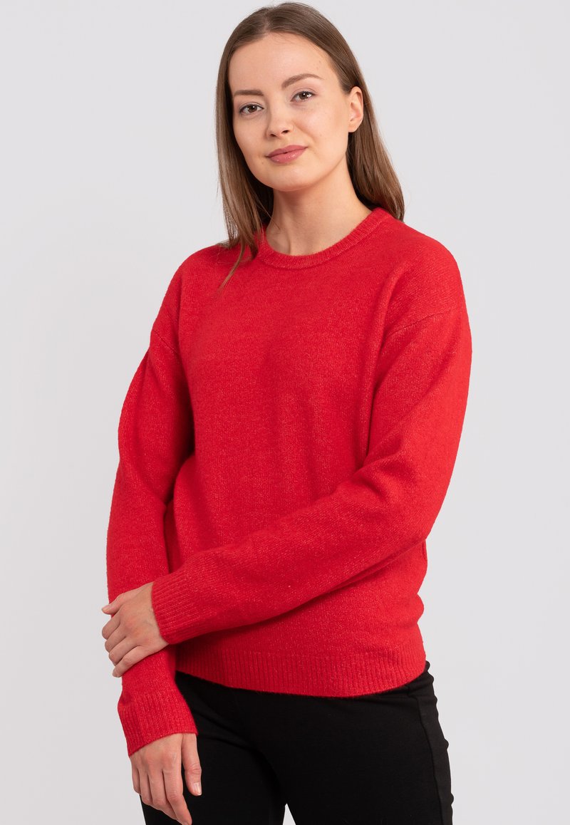 Roter gestrickter Pullover mit rundem Halsausschnitt, langen Ärmeln und gerippten Bündchen. Die Textur wirkt weich und leicht flauschig.