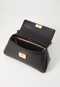 Borsa a mano in pelle nera con chiusura a lucchetto dorato, interno spazioso, texture liscia e forma strutturata, con un rivestimento interno rosa chiaro.