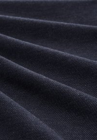 Tissu bleu foncé avec une finition mate, présentant une texture lisse et un léger motif strié, plié pour montrer de la profondeur et de la dimension.