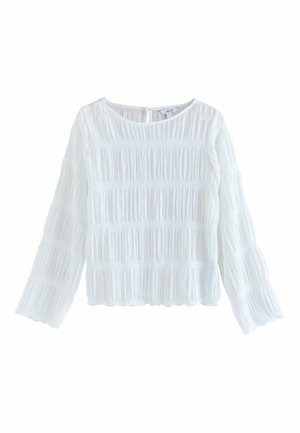 Weiße Langarmbluse aus strukturiertem Stoff mit vertikalen Falten. Sie hat einen runden Halsausschnitt und einen Schlüssellochverschluss auf der Rückseite.