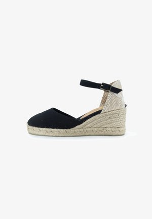 Wedge espadrille in tela nera con suola in juta intrecciata, cinturino alla caviglia e pannello posteriore beige testurizzato. Design classico e versatile.
