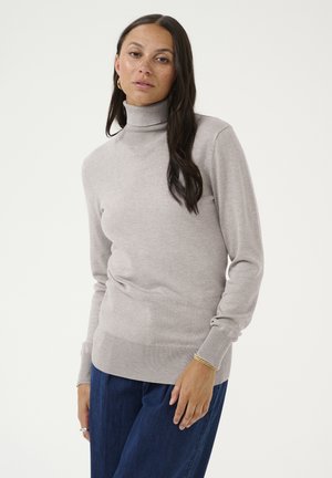 Maglione a collo alto grigio chiaro realizzato in tessuto morbido, con maniche lunghe e bordo a coste, abbinato a pantaloni in denim blu navy.