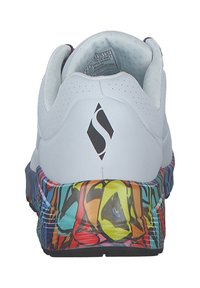 Zapatilla blanca con un upper texturizado, que presenta una suela con un patrón abstracto y colorido, además de un acento de logo negro en el talón.