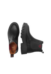 Stivali ankle in pelle nera con suole in gomma, pannelli laterali elasticizzati e un logo a forma di cuore rosso sul tallone. Texture liscia e design della punta rotonda.