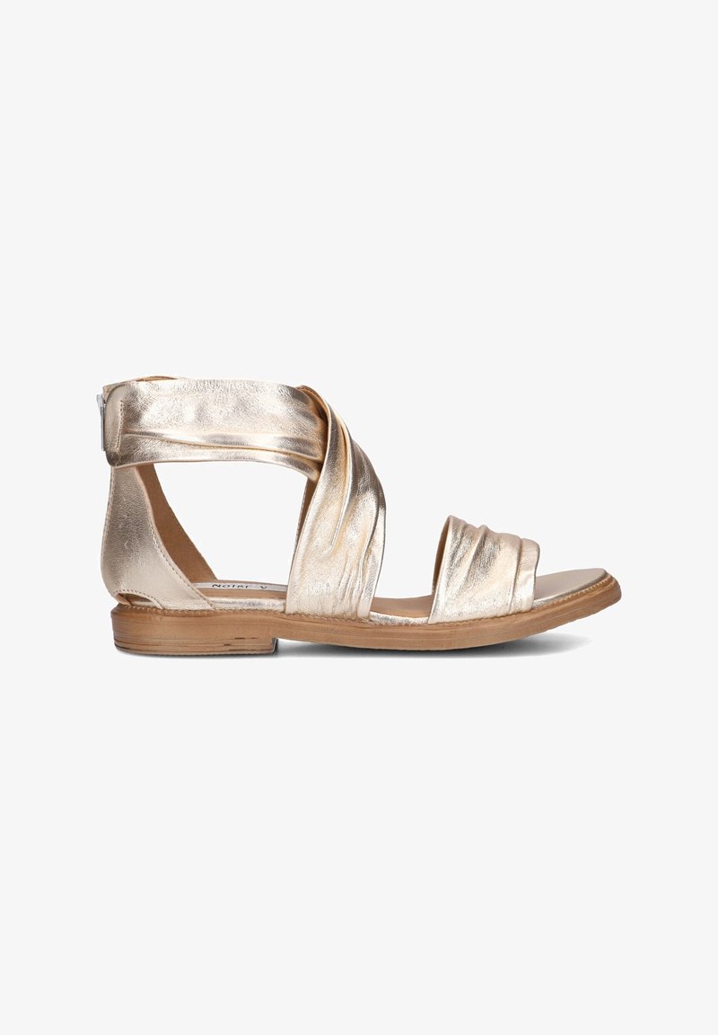 Metallische gouden platte sandals met een gedraaide bandontwerp, open teen en beige zool. Zachte textuur met een minimalistische stijl.