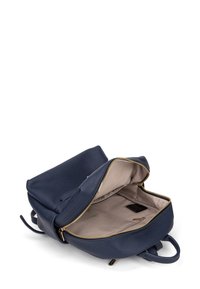 Zaino in pelle blu navy con apertura superiore, interno beige, cerniera dorata, due manici e texture liscia.