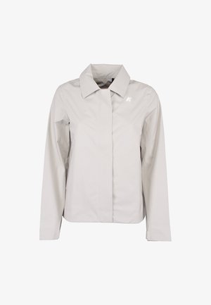 Giacca da donna grigio chiaro con maniche lunghe, colletto appuntito, chiusura frontale nascosta e piccolo logo bianco sul petto sinistro.