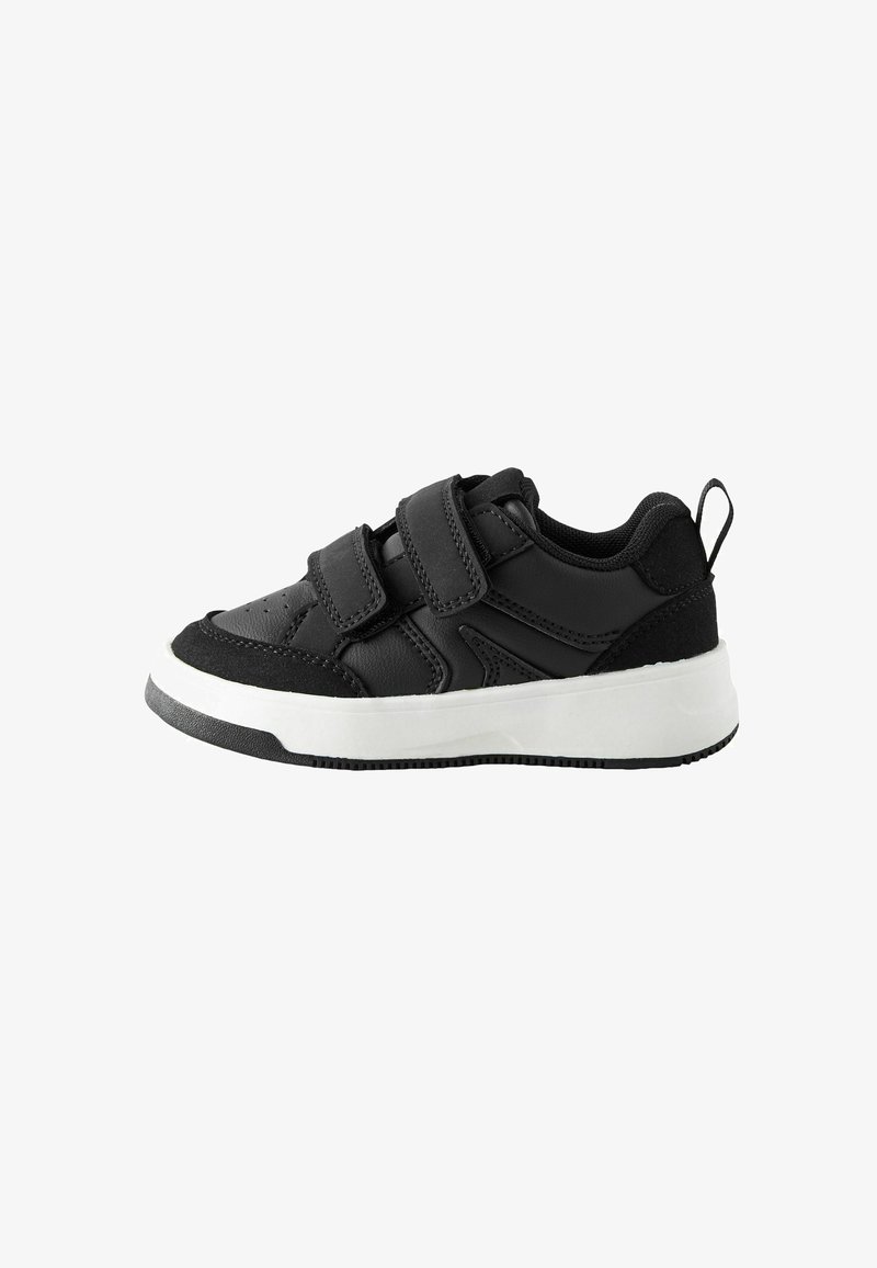 Baskets basses noires avec deux bandes velcro et une semelle blanche épaisse, conçues pour un usage décontracté.