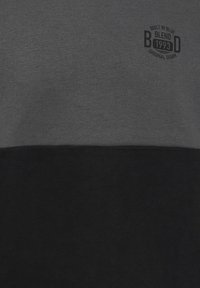 Grijs en zwart kleur-geblokkeerd sweatshirt van een katoenmix; heeft een ronde logo, platte naden en een zachte textuur. Casual ontwerp zonder opvallende accenten.