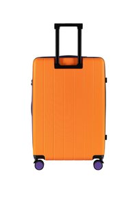 Oranje hard-shell koffer met verticale groeven, uitschuifbare zwarte handgreep en paarse wielen. Compact ontwerp met zijzak met rits.