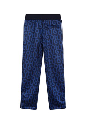 Donkerblauwe joggingbroek van glanzende stof met een herhalend logo patroon. Elastische tailleband, zijstrepen en een ritszak aan de achterkant.