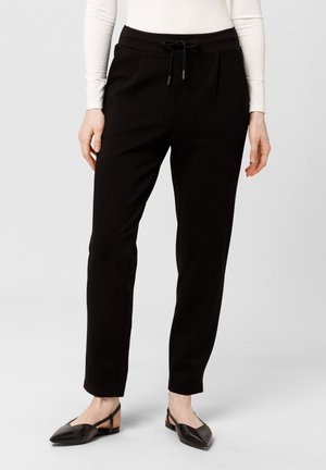 Zwarte broek met een koord in de taille, voorzien van twee zijzakken, een slankere pasvorm en een gladde textuur. Gekleed met zwarte slingback flats.