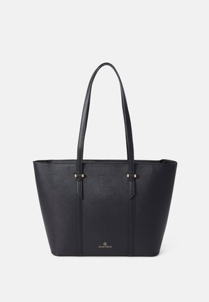 Sac fourre-tout noir en matériau structuré, avec deux longues poignées, des accents en métal doré et un logo de la marque embossé au bas.