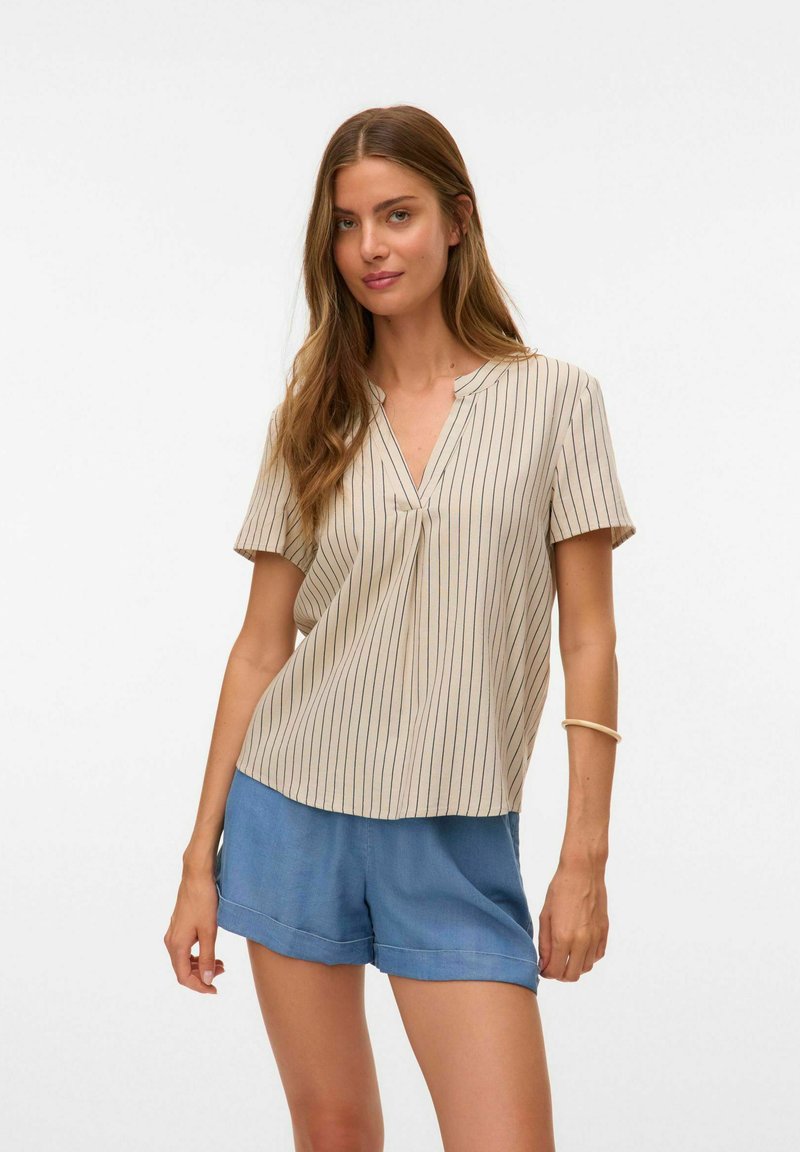 Blouse beige à manches courtes avec des rayures verticales bleu marine, col en V et coupe ample, associée à un short bleu clair, présentée sur un fond neutre.