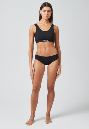 Zwarte sport-bralette en bikiniset met een gladde, rekbare textuur. De bralette heeft een logoband en brede bandjes.