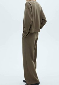 Ensemble de vêtements de détente vert olive en tissu doux ; comprend un sweat-shirt court à manches longues et un pantalon ample à jambes larges.