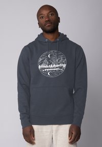 Dunkelgrauer Hoodie mit Kängurutasche. Mit einem runden Grafikdesign von Bergen und Wäldern in Weiß. Weicher Stoff mit lockerer Passform.