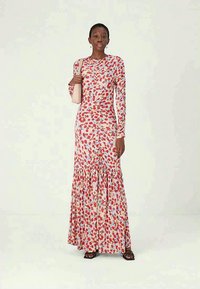 Hosszú ujjú, világos rózsaszín virágmintás ruha piros és kék mintákkal. Ráncolt szegélye, testhez álló fazonja és puha, mintás anyaga van.