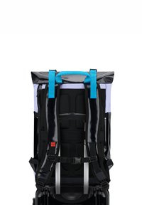 Hátulnézet egy hátizsákról, amely fekete és világoslila anyagból készült, kék pántokkal, felgöngyölhető zárással és párnázott fekete hálós hát támogatással.